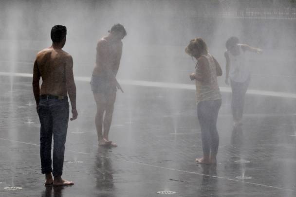 Varias personas se refrescan en una fuente de Madrid Río debido a las altas temperaturas en mayo de 2015. Toda la Comunidad de Madrid, excepto la sierra, permaneció una parte del día en alerta amarilla por altas temperaturas. / EFE/Javier Lizón