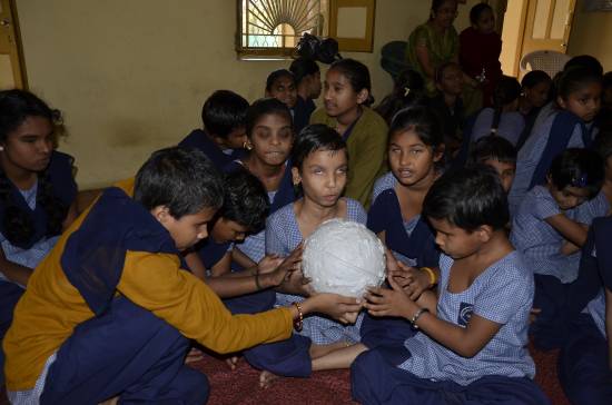 Niñas con ceguera de un colegio de Vadodara (India) tocan la esfera de la Luna gracias al proyecto ‘A touch of the universe’. / Divyadarshan D. Purohit