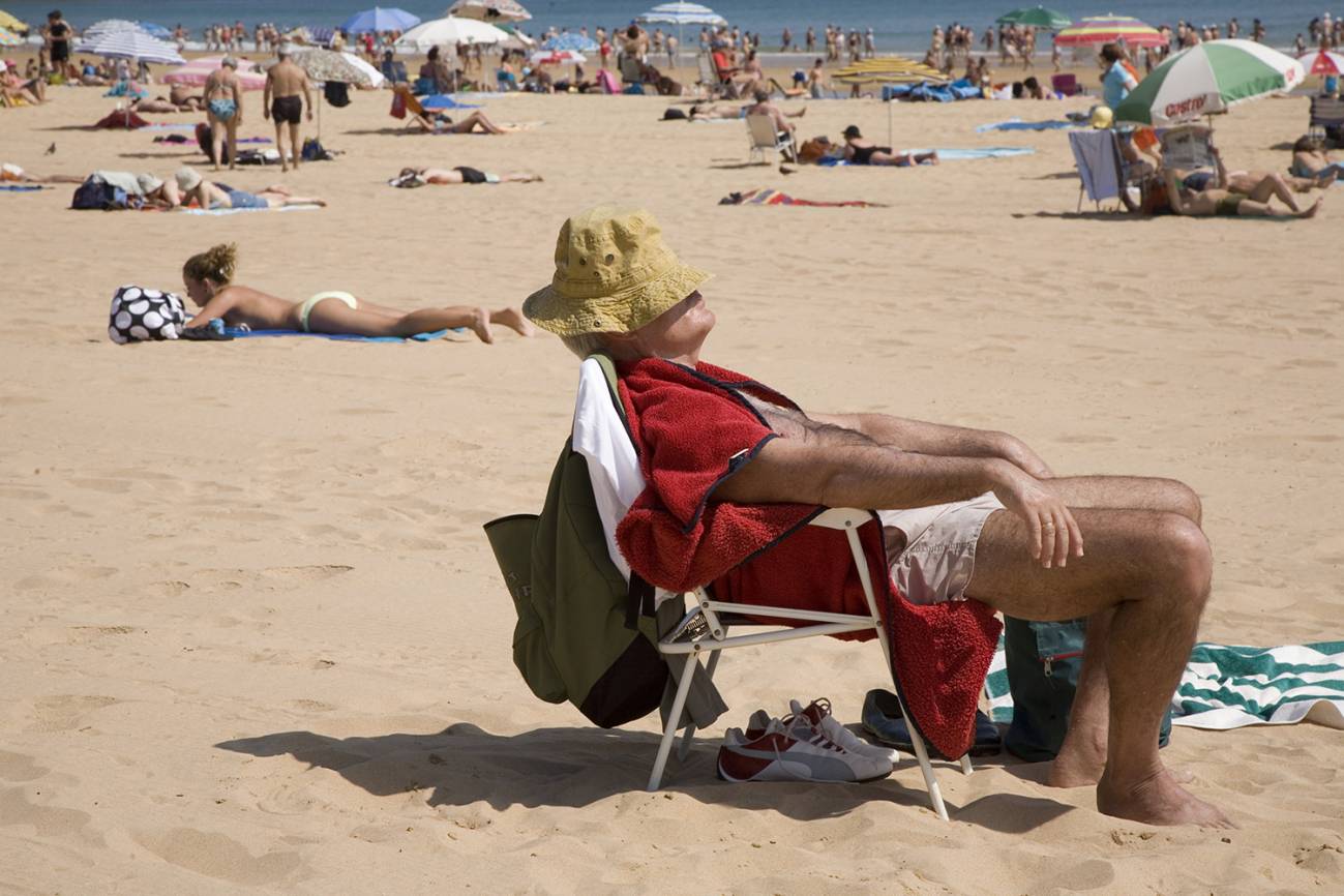 Un hombre toma el sol en una playa. / Joan Costa