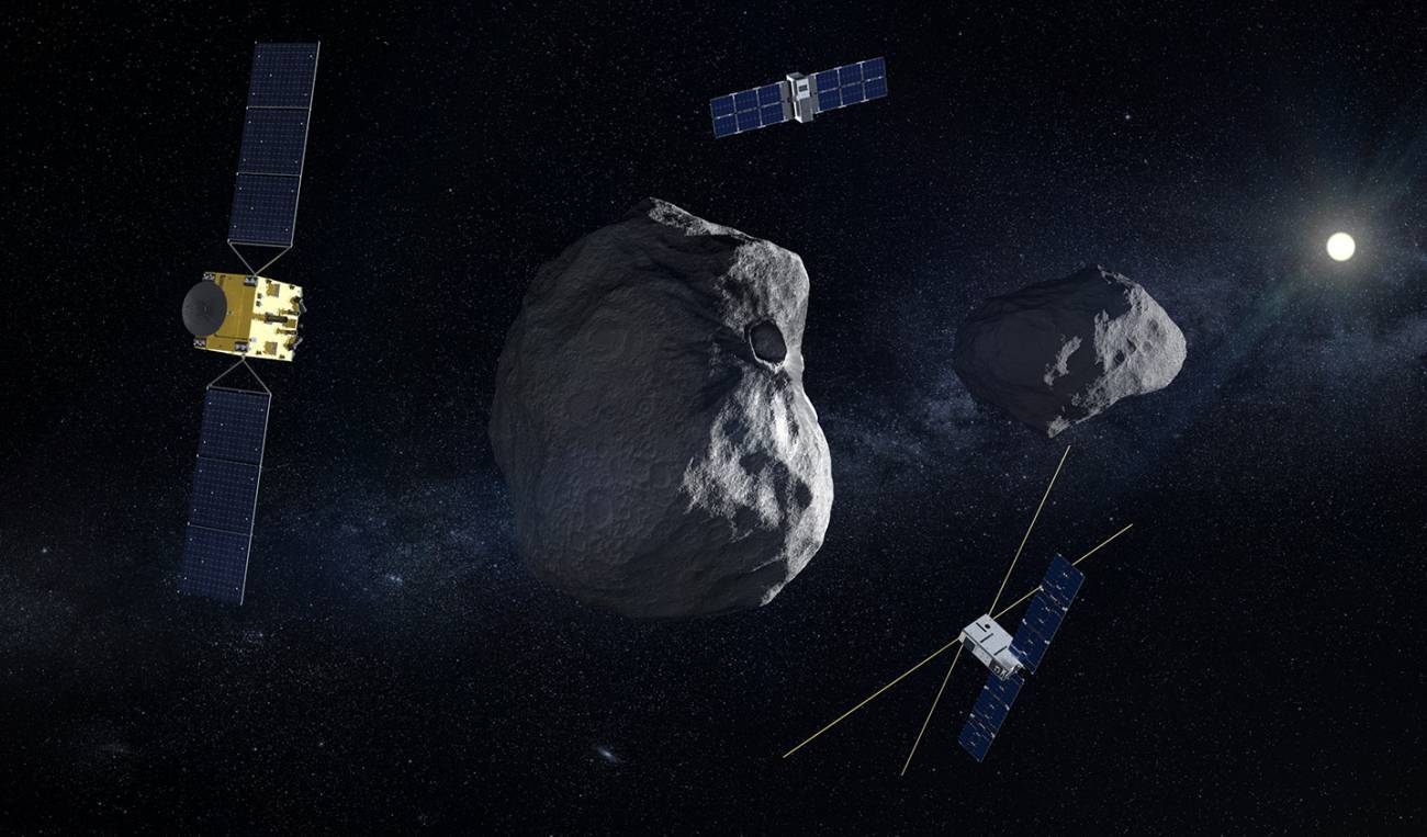 lustración de la nave Hera con sus dos pequeños satélites complementarios (Juventas y Milani). Al fondo el sistema doble de los asteroides Dimorphos (el objetivo principal, donde ha impactado la sonda DART de la NASA) y Didymos. / ESA