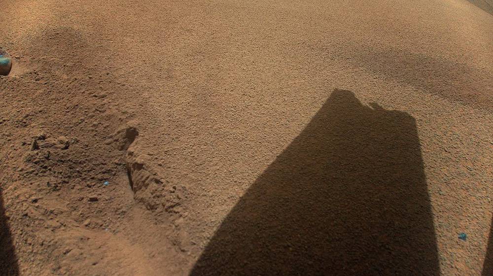 Después de su vuelo número 72, el 18 de enero de 2024, el helicóptero de la NASA en Marte Ingenuity captó esta imagen en color que muestra la sombra de una de las aspas de su rotor, que resultó dañada durante el aterrizaje. / NASA/JPL-Caltech