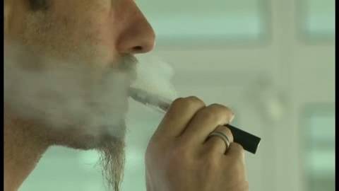 Hombre fumando un cigarrillo electrónico.