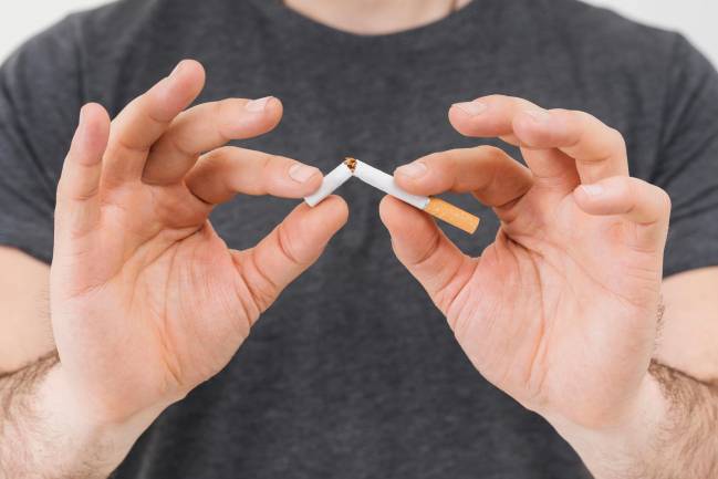 hombre rompiendo un cigarrillo