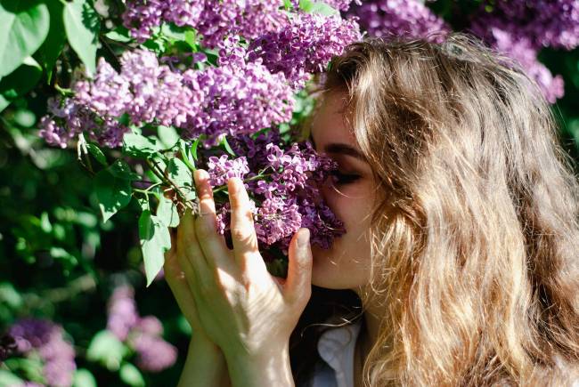 Mujer oliendo flores