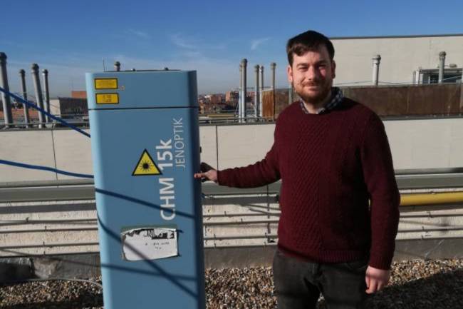 El investigador Roberto Román muestra el ceilómetro en la terraza de la Facultad de Ciencias de Valladolid. / DICYT