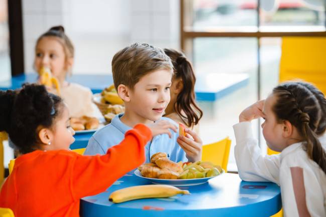 Niños hablando en un comedor. / Pexels