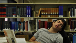 hombre durmiendo en una biblioteca