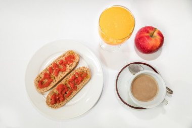 <p>Imagen de un desayuno energético: una taza de café, leche o yogur, fruta y pan integral con tomate y aceite de oliva. / CNIC</p>