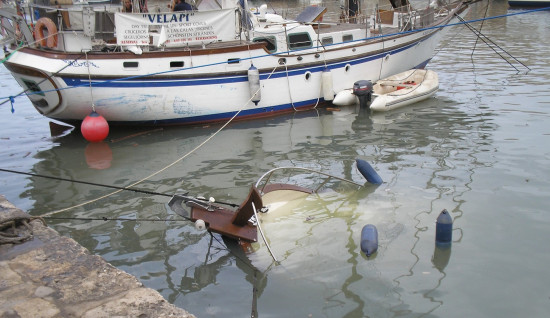 Embarcación hundida por una rissaga que sufrió el puerto de Ciutadella / Joan Martinez