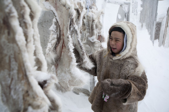Niño inuit limpiando pieles para confeccionar ropa (Canadá) / EFE