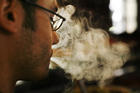 Un hombre fuma un cigarrillo.