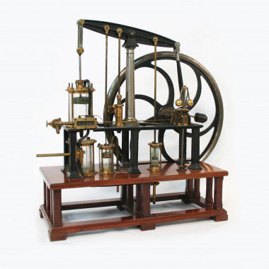 <p>Modelo de máquina de vapor (1890-1910). En las máquinas de vapor, el movimiento de vaivén del émbolo se transforma, por medio de un sistema de bielas y excéntricas, en el de rotación del gran volante de inercia.</p>