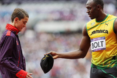<p>El atleta jamaicano Usain Bolt le entrega su gorra a un voluntario antes del comienzo de las mangas clasificatorias de los 200 metros masculinos de los Juegos de Londres. Imagen: Efe</p>