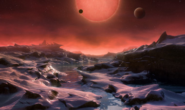 <p>Ilustración de la estrella enana ultrafría TRAPPIST-1 desde la superficie de uno de sus planetas. Los otros dos se ven a lo lejos. / ESO/M. Kornmesser</p>