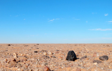 <p>Fragmento negro del meteorito Almahata Sitta encontrado en el desierto de Nubia en Sudán. / P. Jenniskens (SETI Institute/NASA Ames)</p>