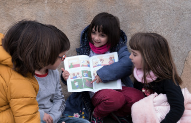 <p>Niñas y niños leen el cómic del proyecto. / IHC</p>