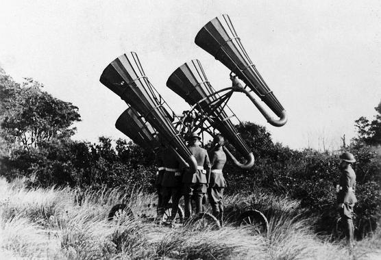 <p>En la imagen, un localizador acústico. Las enormes bocinas amplificaban sonidos a kilómetros de distancia, que eran monitorizados a través de los auriculares por un soldado, lo que le permitía dirigir la plataforma para identificar los aviones enemigos. / National Archives</p>