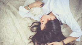 mujer durmiendo en una cama con un perro