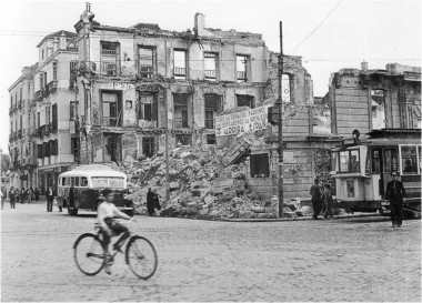 <p>Gijón, destruido tras la guerra civil, con una pancarta en la que puede leerse: sobre las ruinas del marxismo edificaremos la nueva España. ¡Arriba España!. / Fondos de la Universidad de Oviedo</p>