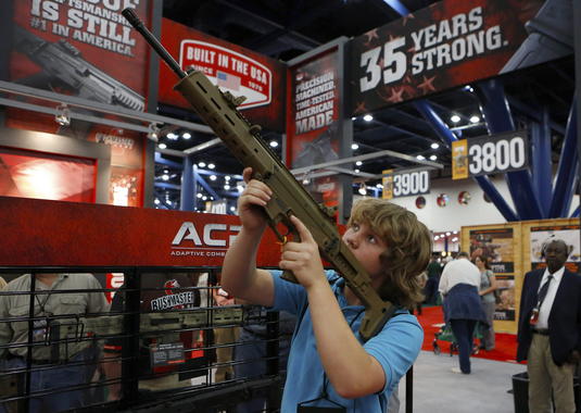 <p>Un niño de 13 años prueba un arma en la convención anual de la Asociación Nacional del Rifle en Houston (EE UU)./ Efe</p>