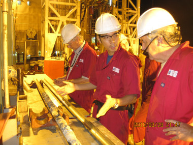 <p>El autor principal, Yusuke Yokoyama, en el centro, y Juan Carlos Braga, a la derecha, observando un testigo de roca recién sacado de un sondeo en el turno de noche a bordo del Greatship Maia. A / UGR</p>