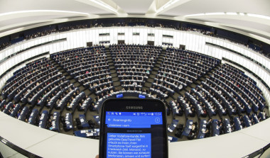 <p>Una persona muestra un SMS con información de roaming en su teléfono móvil durante el pleno del Parlamento Europeo en Estrasburgo (Francia) ayer. EFE / Patrick Seeger</p>