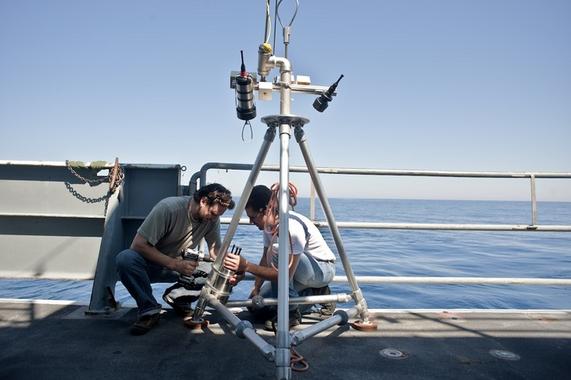 <p>Timothy Crone (a la izquierda) prepara una cámara para monitorizar el flujo de las fumarolas en el Pacífico noroeste. Esta tecnología permitió estimar el flujo del vertido en el Golfo de México. <a href="http://www.plataformasinc.es/index.php/esl/imagenes/inicio/(imagen)/62253" target="_blank">Foto:</a> Carlos Sanchez/Universidad de Washington (EE UU).</p>