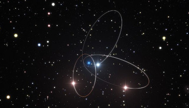 <p>Ilustración de las órbitas de tres estrellas cercanas al agujero negro supermasivo (círculo azulado) del centro de la Vía Láctea. / ESO/M. Parsa/L. Calçada</p>