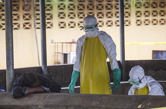 <p>Trabajadores de salud liberianos se preparan para recoger el cuerpo de una víctima del ébola del área de espera de un hospital en Monrovia. / Efe</p>