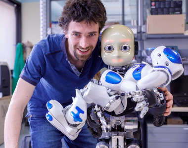 <p>El investigador Matej Hoffmann, con los robots humanoides iCub y Nao (en brazos). / Duilio Farina, Instituto Italiano de Tecnología. </p>